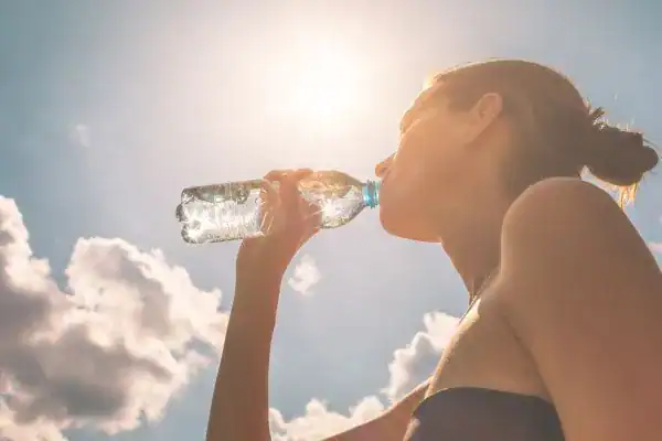 Hydration: The Secret Ingredient for a Toned Stomach and Enhanced Fitness 3 Image of woman drinking water to hydrate Bellshill after run.