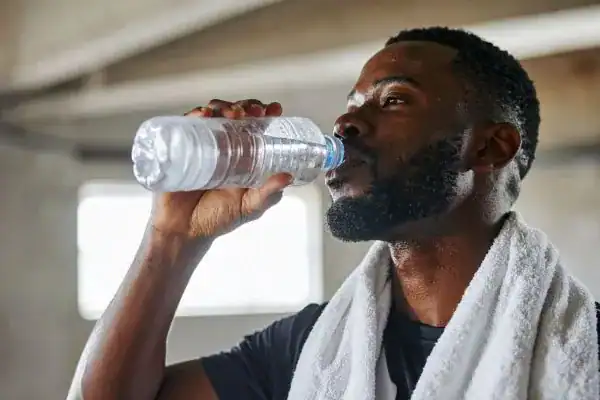 Hydration: The Secret Ingredient for a Toned Stomach and Enhanced Fitness 1 Image of man drinking water to improve hydration Bellshill after work out.